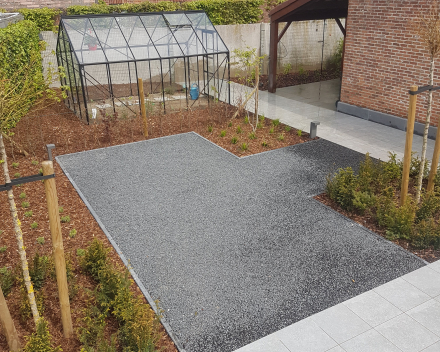 Tuinaanleg - volledige aanleg van de tuin: aanleg terras met keramische tegels in combinatie met grindmatten, uitvoeren van aanplantingen en plaatsen van een serre